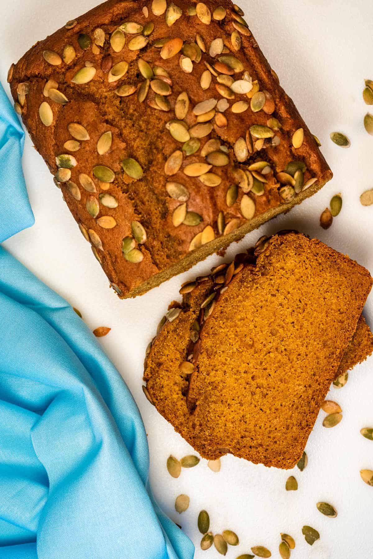 Overhead view of a loaf and slices of vegan pumpkin bread.