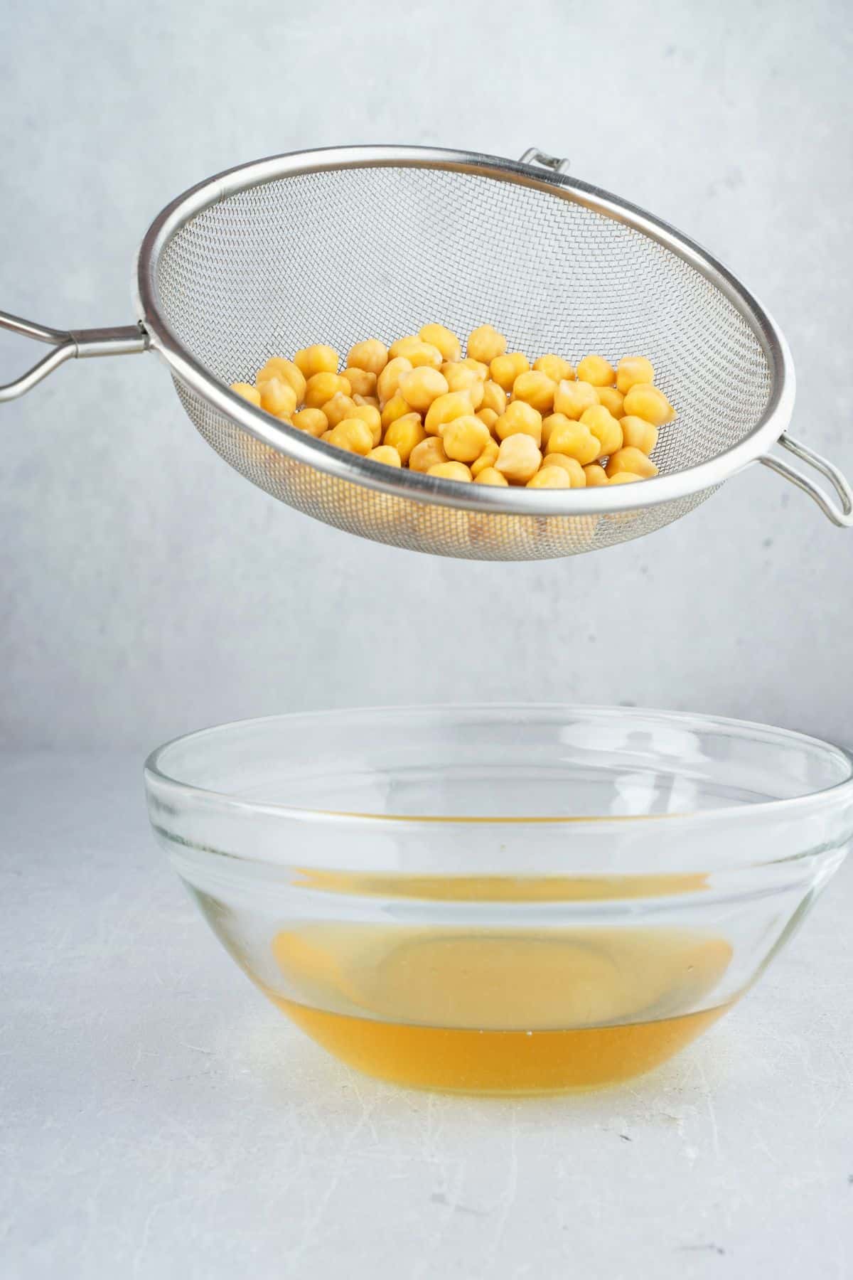 chickpeas being drained to remove the liquid aquafaba