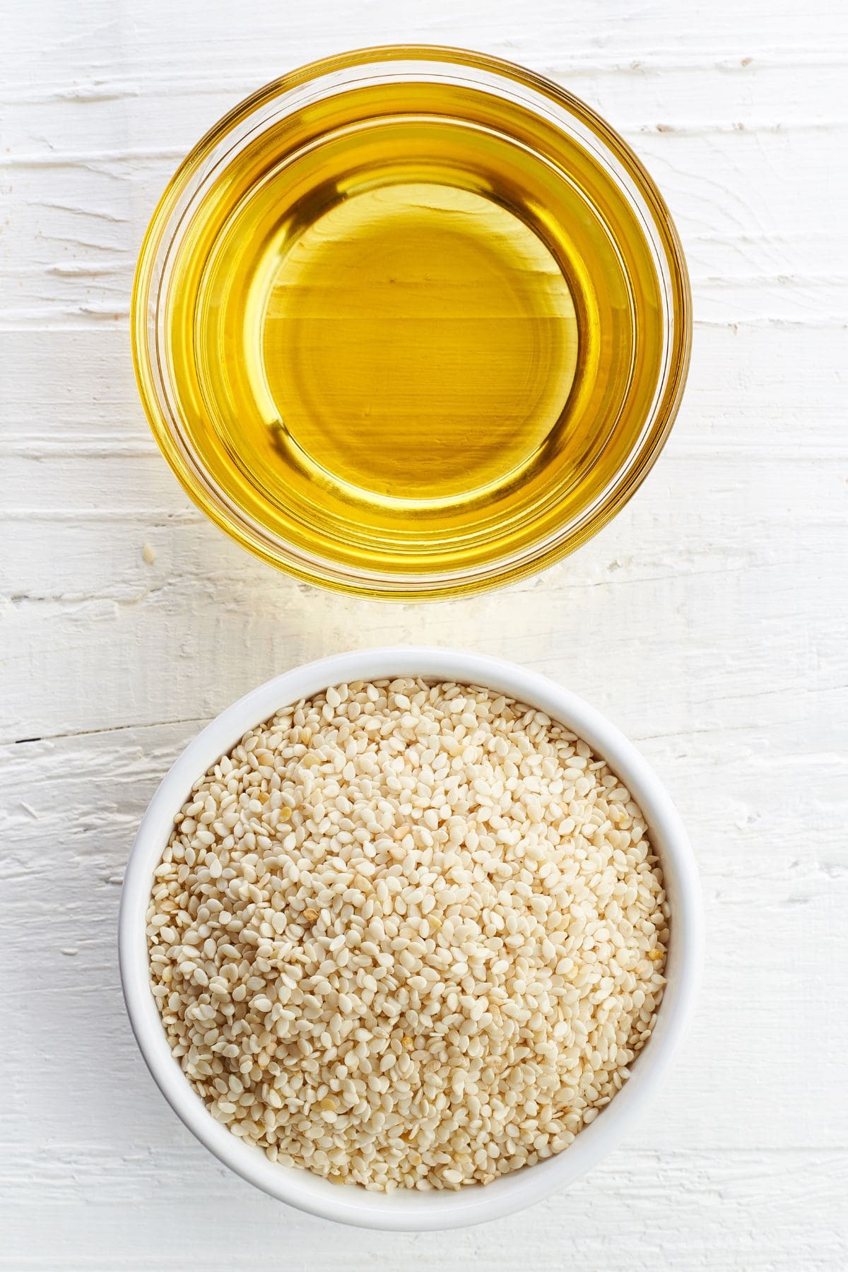 a dish of oil and a dish of raw sesame seeds