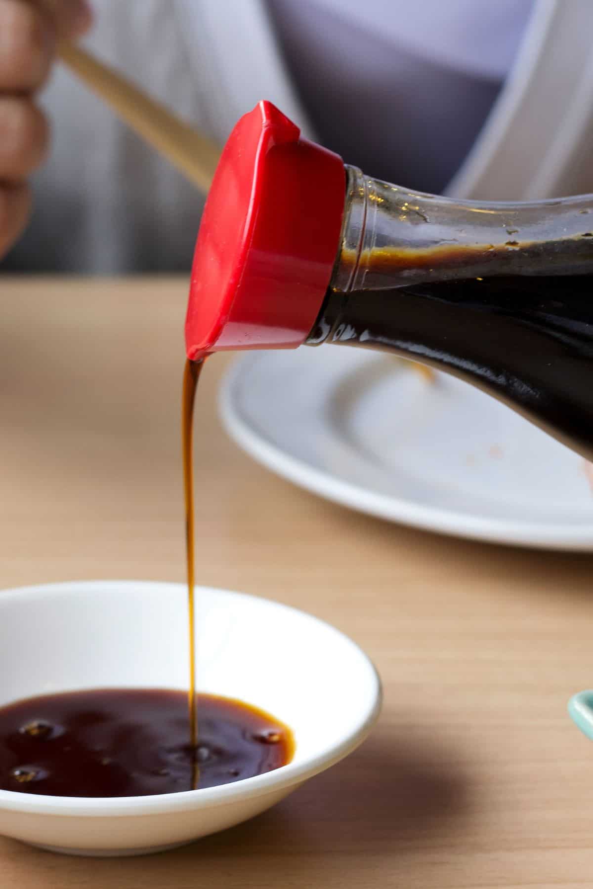 soy sauce being poured into a dish